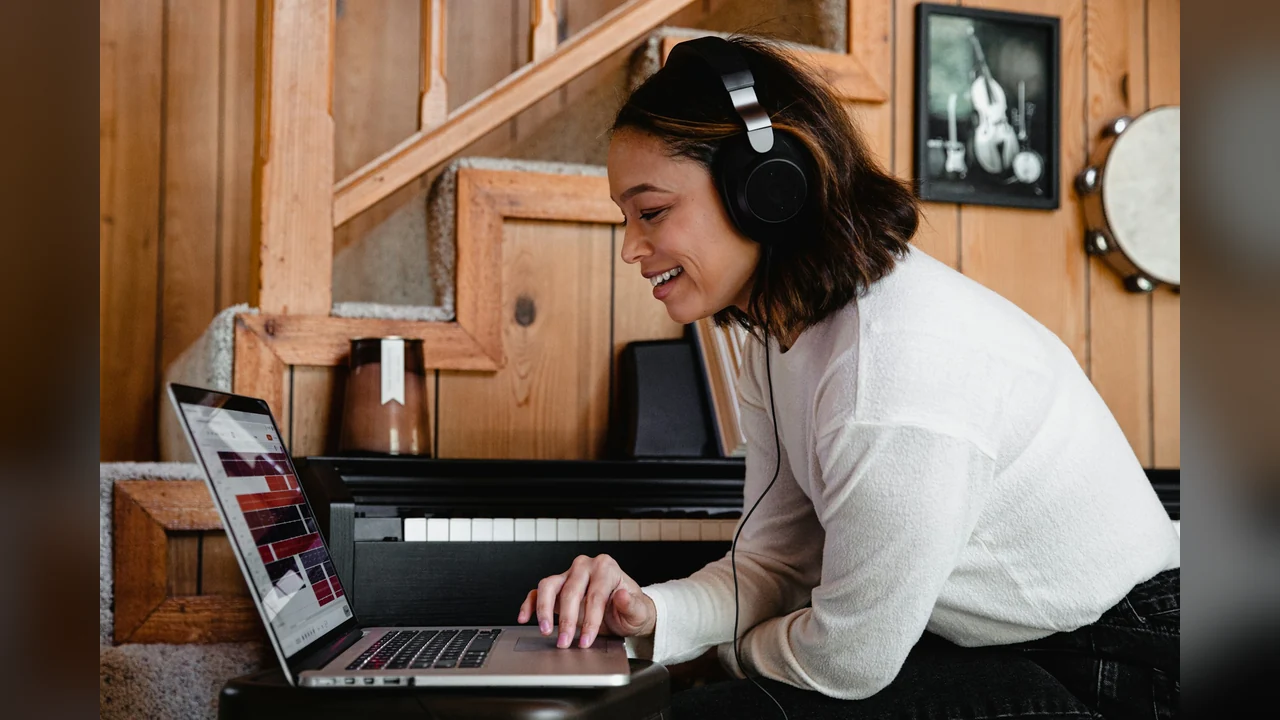 AIRapGenerator: typing a one-line song idea on a laptop with headphones on